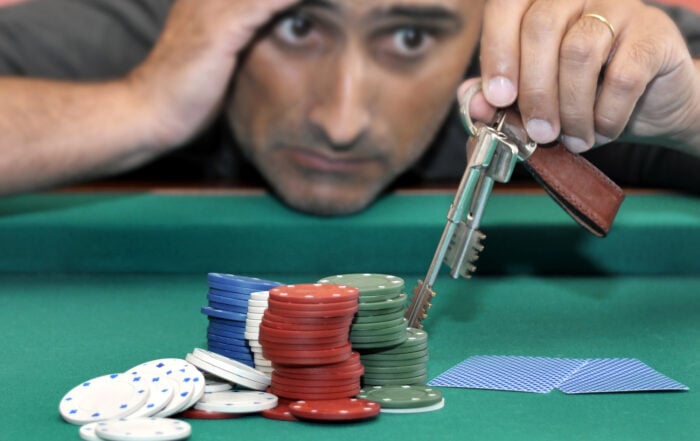 Stressed man in a poker table gambling his house