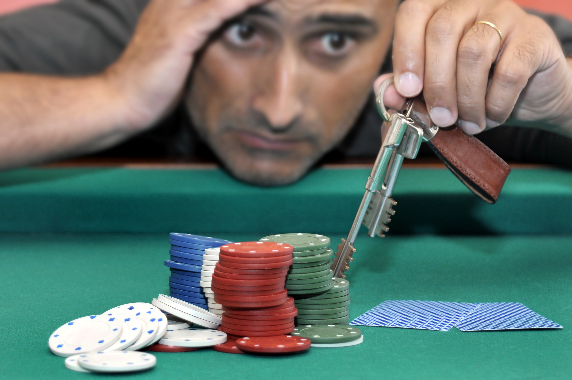 Stressed man in a poker table gambling his house